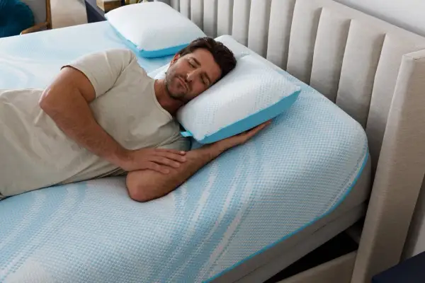 Man sleeping peacefully on a Tempur-Pedic pillow, enjoying the comfort and subtle, fresh tempurpedic pillow smell.